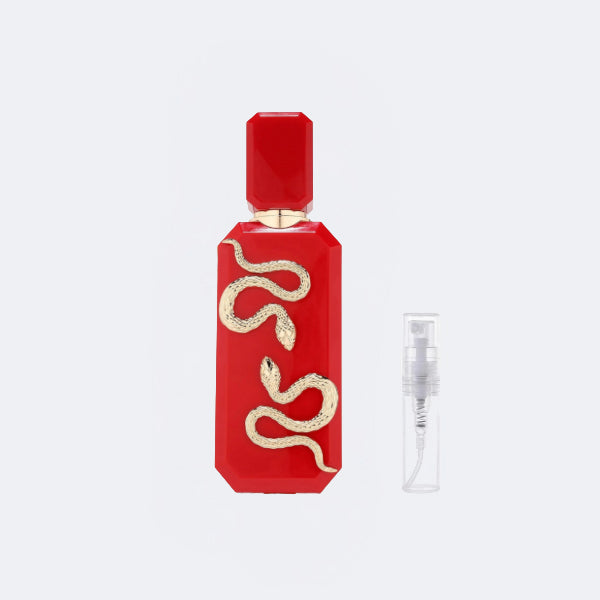 Red perfume bottle with gold snake design on a white background