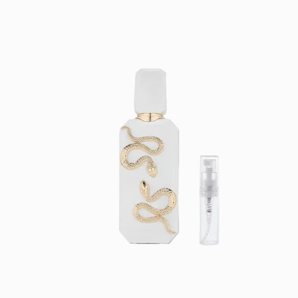 White perfume bottle with gold snake design on a light gray background